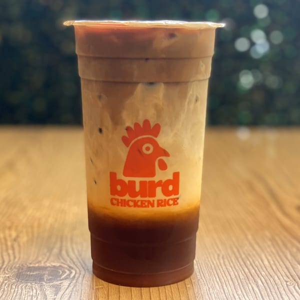 A Burd Chicken Rice branded iced coffee drink with layers of dark coffee and creamy milk.